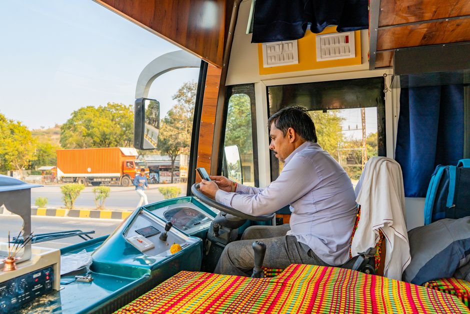 Een buschauffeur in Nederland achter het stuur van een bus, met aandacht voor verkeersveiligheid en leeftijdseisen.