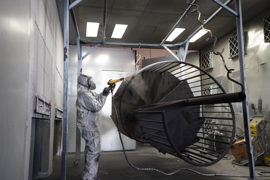 Een vakman die meubels spuit voor een modern en duurzaam design in een lichte, professionele werkplaats.